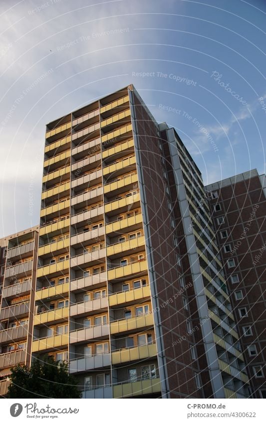 Prefabricated building in the evening light Prefab construction Balcony Evening sun High-rise High-rise facade GDR architecture Rostock student flat Sky Clouds