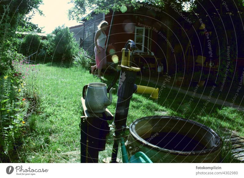 Allotment garden idyll Garden plot Garden allotments Garden shed Well Woman Gardenhouse Idyll Love of nature tranquillity in the country Water jug being out