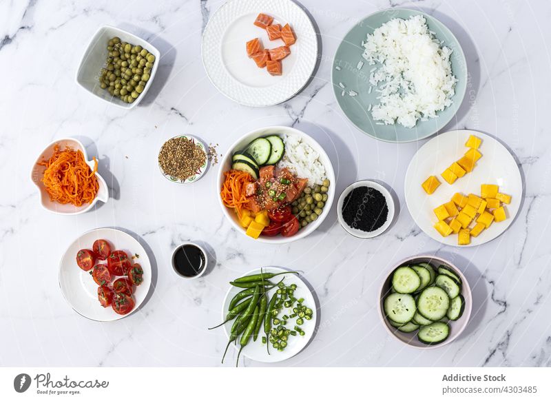 Raw ingredients for poke dish cook recipe raw oriental table fresh natural tradition cuisine prepare asian salmon rice pea mango cucumber carrot cherry tomato