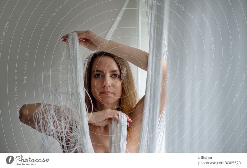 Portrait of a beautiful young attractive sexy woman,playing with hands decorative with a string curtain thread nude naked topless fall mask portrait mouth chin