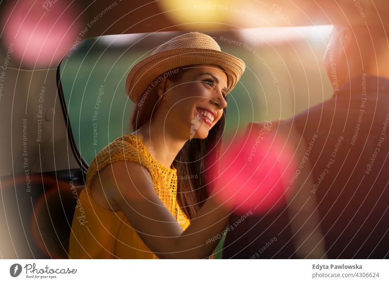 Young couple sitting in their car trunk and watching the sunset lights camper camping summer holiday sunrise sleeping vehicle road trip hippie meadow