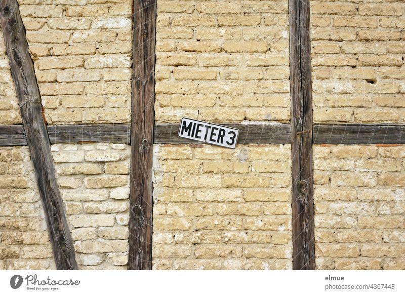 A sign with the inscription MIETER 3 is attached to a wooden beam of a half-timbered house / reserved parking space Tenant parking Half-timbered house