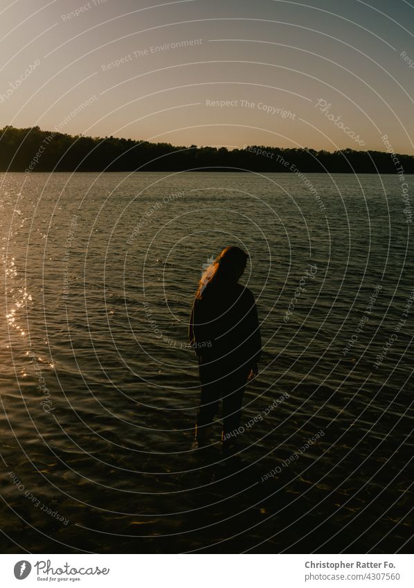 In the evening with both legs in a cool clear lake in the hot summer in Mecklenburg-Western Pomerania Nature Shadow Visual spectacle Deserted silent melancholy