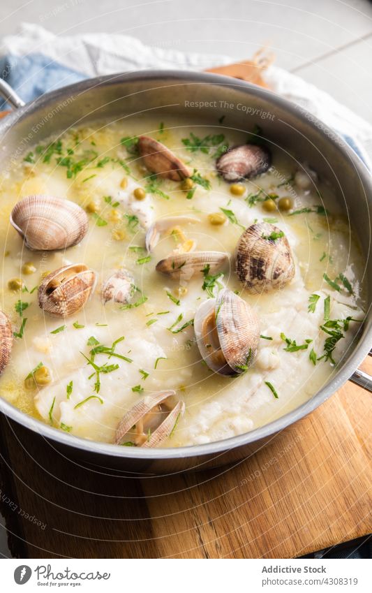 Saucepan of seafood soup in kitchen saucepan board meal delicious lunch cuisine tasty dish hake fish clam herb pea ingredient recipe yummy prepare appetizing