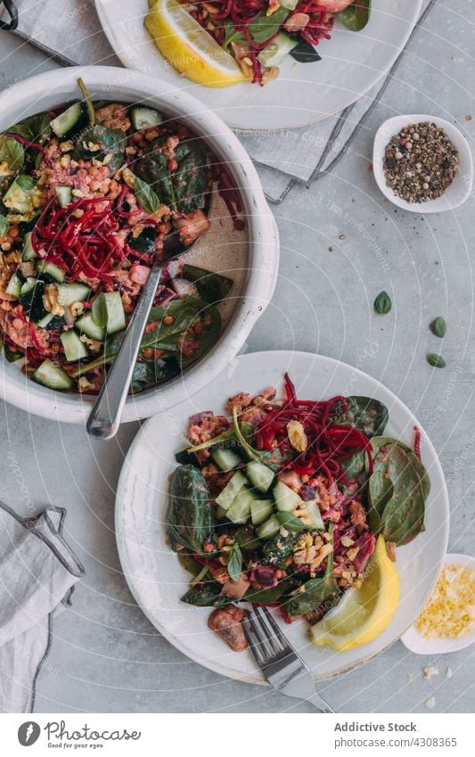 Tasty lentil salad on gray table food healthy napkin cucumber spinach fresh dish ingredient organic meal bowl plate silverware spice gourmet cuisine nutrition