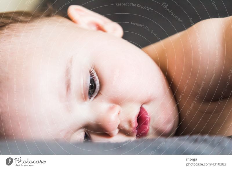 portrait of adorable baby lying babycare babyhood beautiful beauty boy caucasian child childcare childhood closeup cute emotion excitement expression eyes face