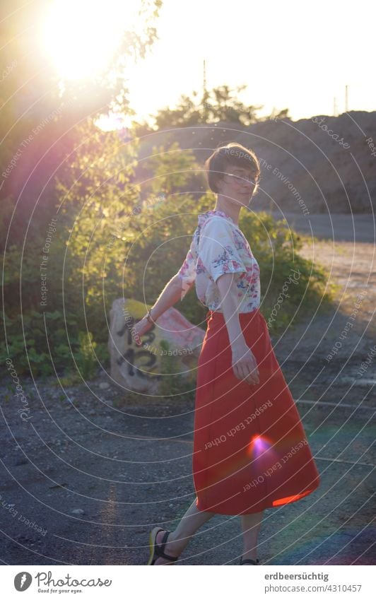 Dancing in the sunlight. Young woman with red skirt dancing on fallow land in the sunlight Woman Elated fortunate Sun Sunlight Back-light FALLOW LAND