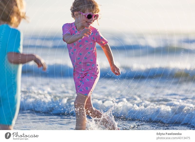 Children playing on the beach young siblings fun family girls children kids New Zealand daytime oceania outdoors scenery travel landscape nature scenic woman