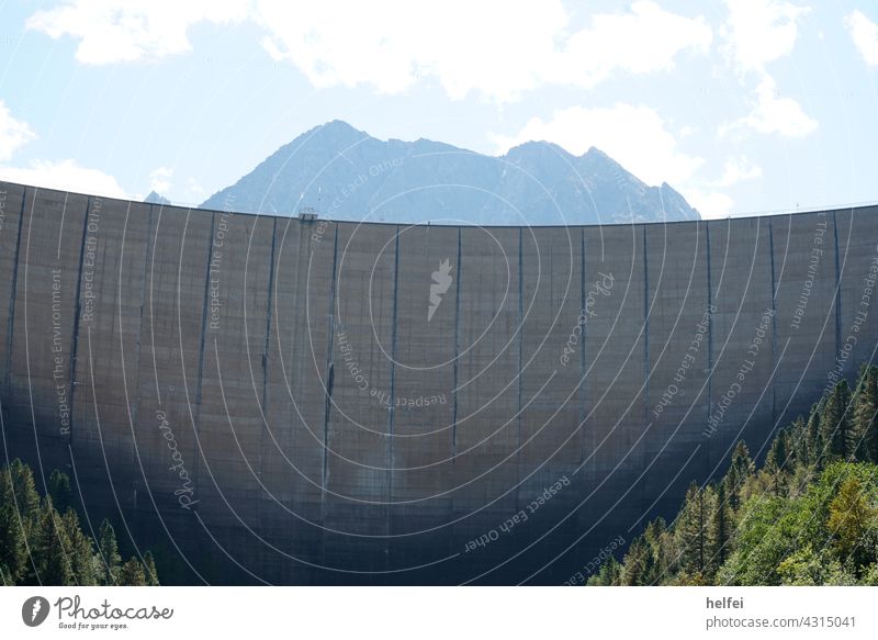 Dam wall of a reservoir in Austria with mountains and blue sky as background Retaining wall Reservoir Sky Lake Water Mountain Clouds Landscape Blue Colour photo