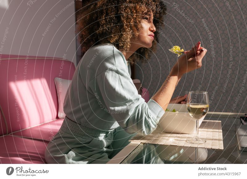 Black woman eating lunch at home salad wine food dish drink meal female ethnic black african american table delicious fresh alcohol wineglass tasty portion