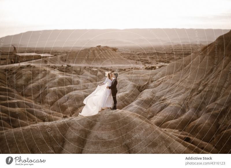 Newlyweds embracing near rock at sunset couple newlywed embrace mountain love honeymoon nature romantic together navarra hug spain bardenas reales natural park