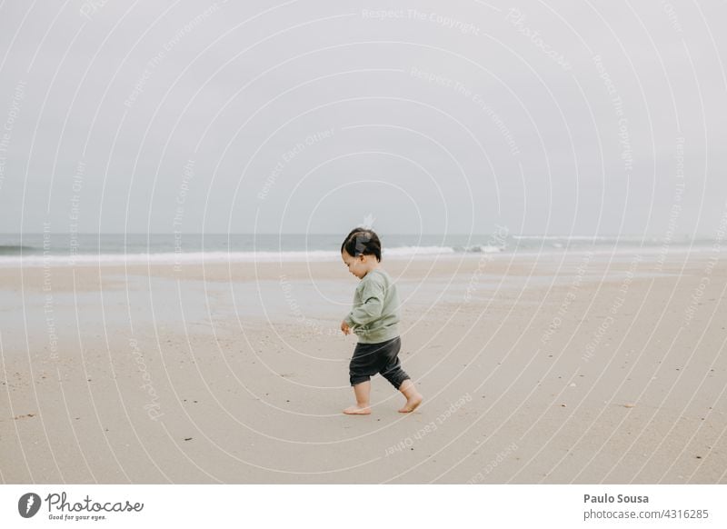 Child at the beach childhood Walking Sand Sandy beach Ocean Authentic Caucasian 1 - 3 years Exterior shot Playing Day Toddler Human being Lifestyle Joy Infancy