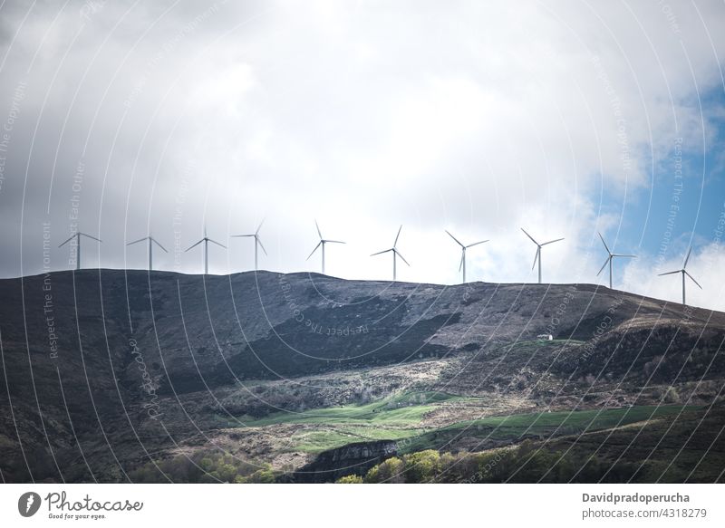 Windmill turbines on grassy hilly terrain windmill power hillside valley energy alternative nature plant propeller landscape environment cantabria spain