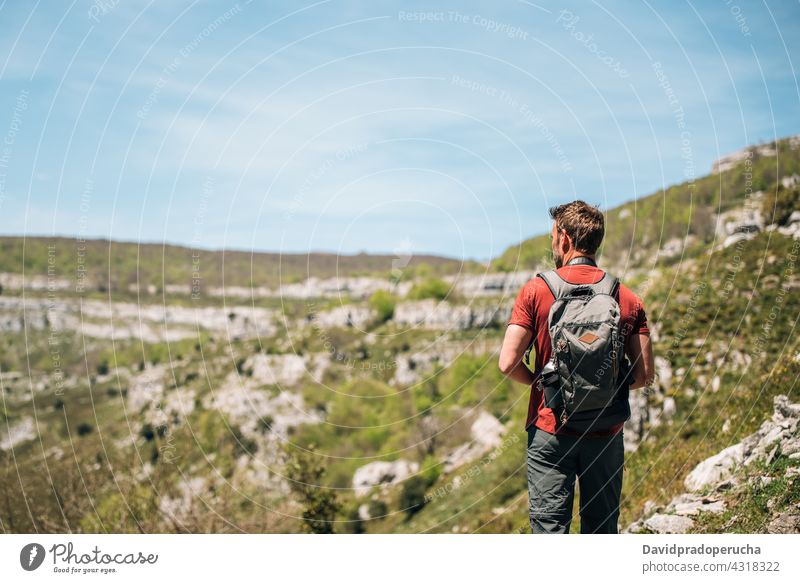 Traveler with backpack standing on cliff hiker admire rocky highland scenery mountain explore nature adventure tourist freedom editorial range tourism travel