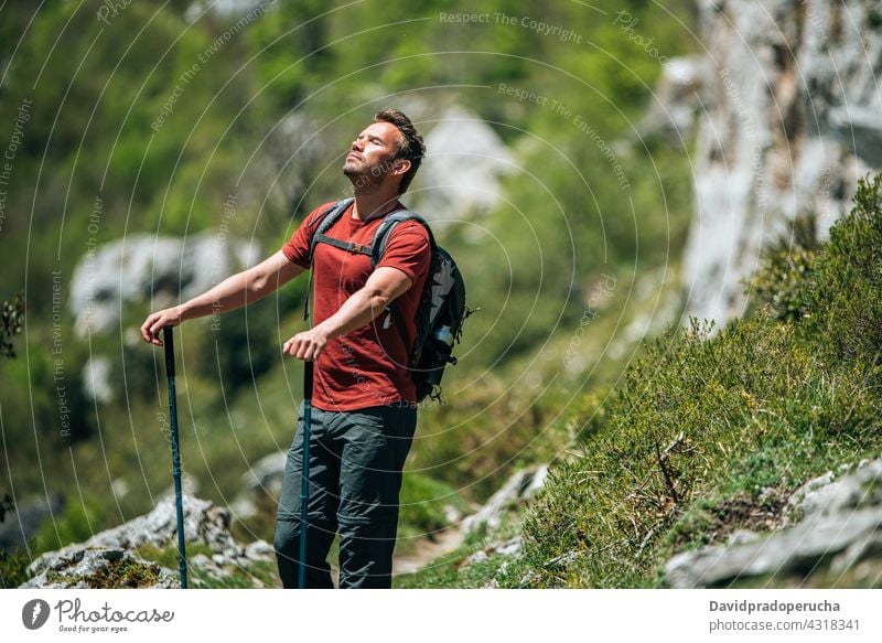 Male hiker walking with trekking poles in mountainous terrain tourist highland backpack rock tourism nature traveler adventure explore stick activity wanderlust