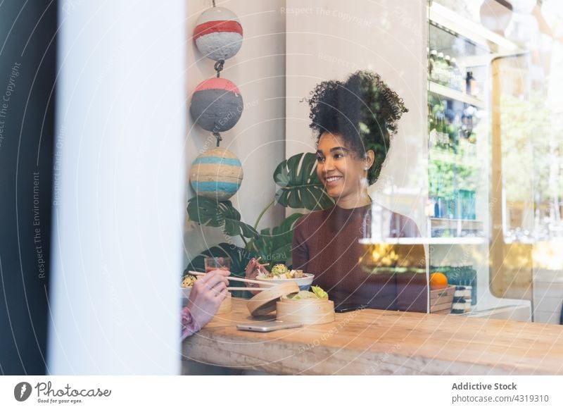 Diverse friends eating in restaurant together spend time weekend poke dish tasty friendship multiracial multiethnic diverse african american black smile food