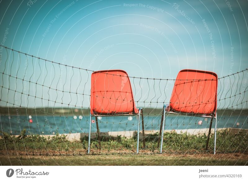 Two unoccupied chairs for lifeguards at the lakeshore Lake Lakeside Water vacation Lifeguard Observe cordon Blue Orange Chair 2 Empty Seating stacking chair