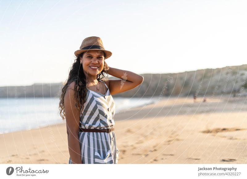 Portrait of a beautiful young woman on the beach by sunset portrait sunny summer algarve portugal brazilian joyful happiness outdoor brunette hispanic enjoy