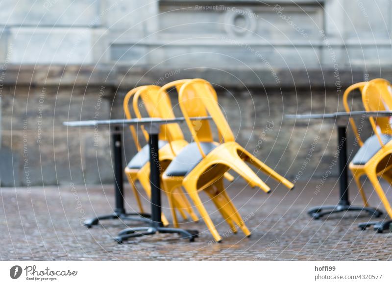 chairs leaning against tables in a street café - end of season End of the season Bistro Closed Bad weather Autumn Rain Café Sidewalk café Terrace Table Chair