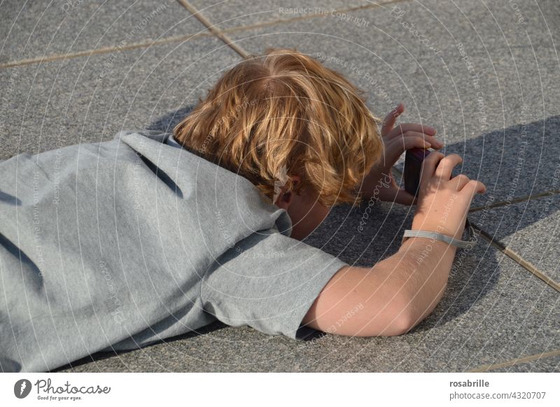 from behind | child on the floor taking photo Child Take a photo Back Photographer recording Ground Boy (child) Summer fun hobby Leisure and hobbies Camera