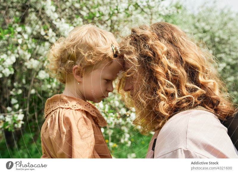 Mother and little girl in summer park mother daughter care child love together parent help tender bonding childhood relationship kid mom cute forehead adorable