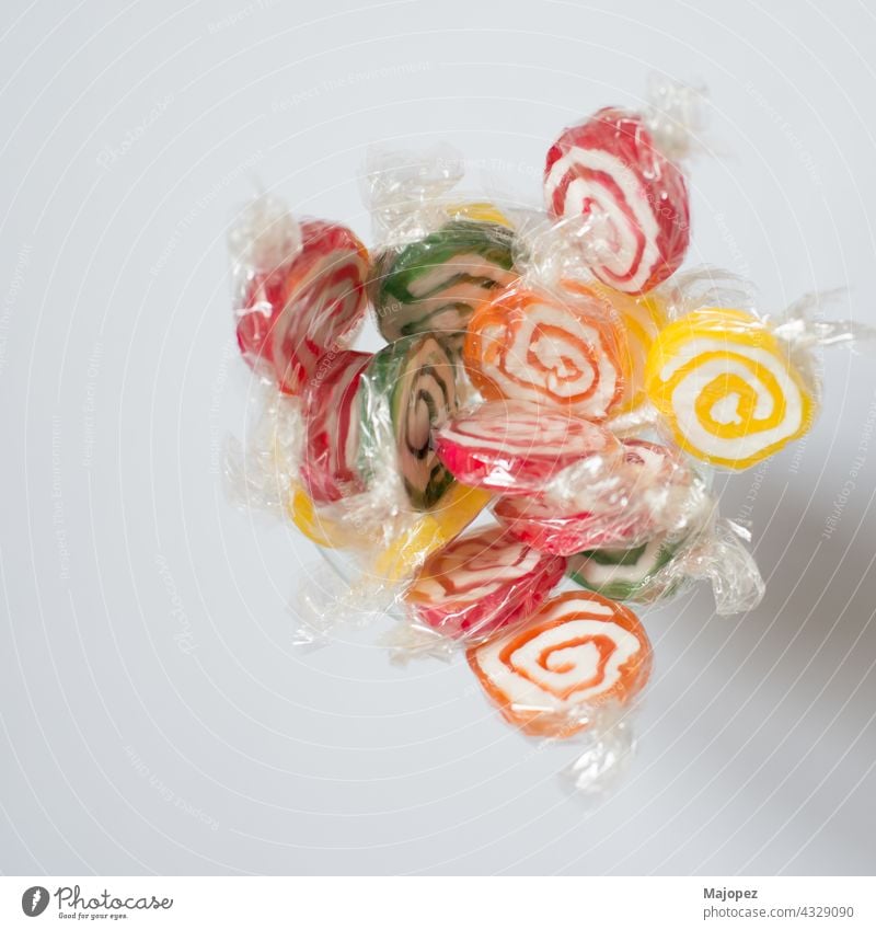 Handful of colorful lollipops seen from above. Red, green, yellow and orange. With white background candy child childhood circle colorful pattern concept