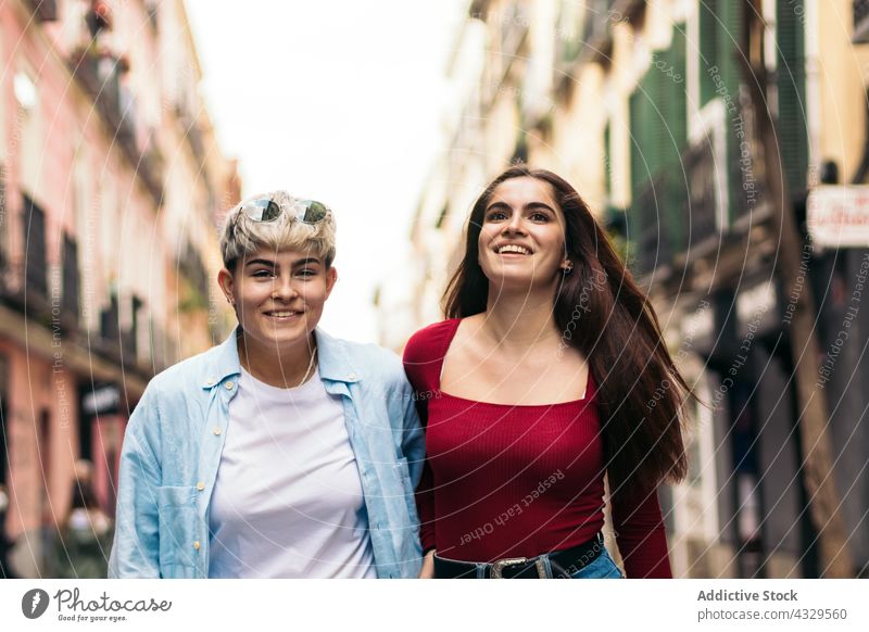 Two teenager girls walking and smiling on a street young two lifestyle people summer urban fashion female happy outdoor woman city person beautiful friendship