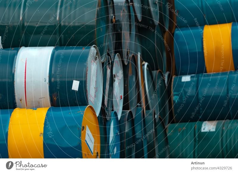 Old chemical barrels stack. Blue, green, and yellow chemical drum. Steel tank of flammable liquid. Hazard chemical barrel. Industrial waste. Empty chemical barrels at the factory warehouse.