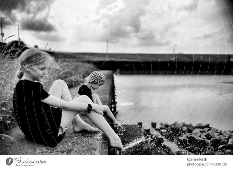 Children at the water children Water cooling Inject Cool feet quay wall dollar Drops of water Cooling Refreshment Swimming & Bathing Wet Summer Exterior shot