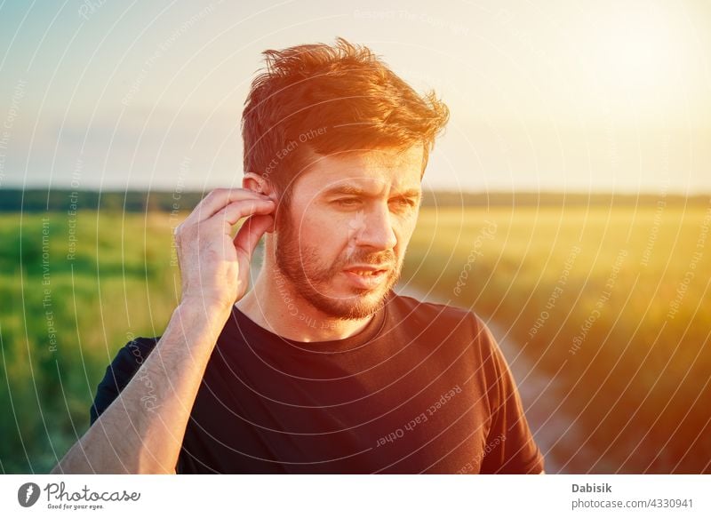 Active millenial man portrait outdoors at sunset sport caucasian lifestyle athlete fitness generation headphones beard casual exercise outside sporty young