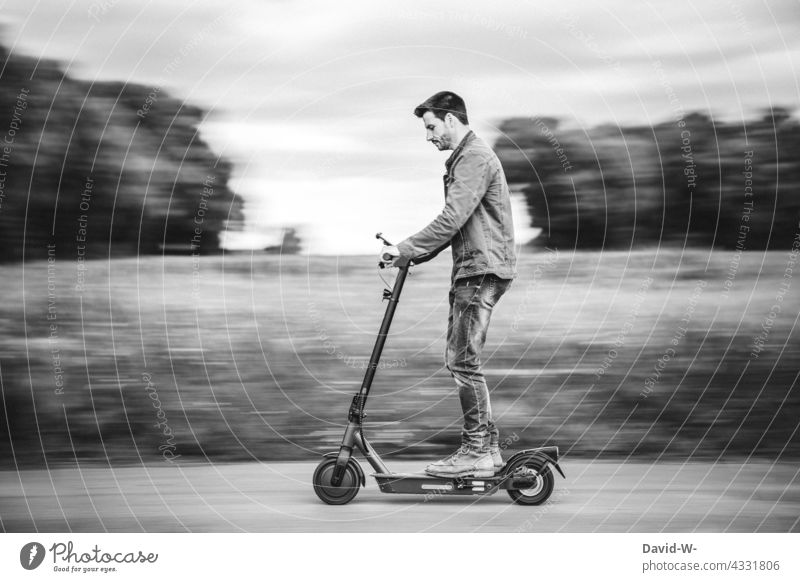 Man riding an e-scooter e-roller electric scooter Driving swift In transit Future Nature mobile Street Electric Modern