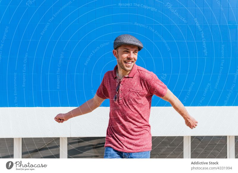 Happy man in trendy outfit on street happy summer having fun joy sunlight style carefree enjoy male positive freedom young beard polo optimist cheerful glad