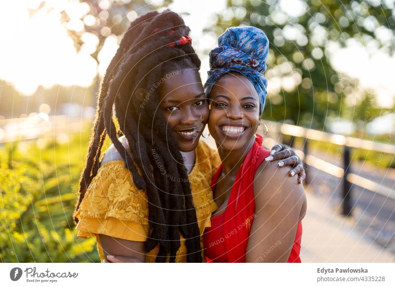 Portrait of two beautiful women standing together outdoors diversity millennials friends friendship sisterhood black live matter afro proud real people candid