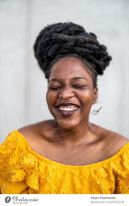 Joyous woman in front of wall dreadlocks proud real people city life African american afro american Black ethnicity sunny sunset outside girl one person adult