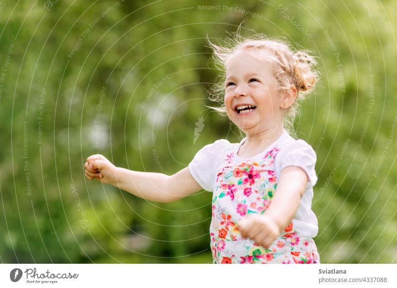 Happy laughing baby girl running in a clover fieldA happy laughing baby is running around the park or garden. Summer, summer time, happy days outdoor fun