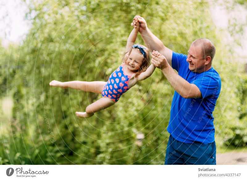 A cute father and a little girl are playing together. The child takes off in the hands of his father baby flying daughter man park family day love happy dad