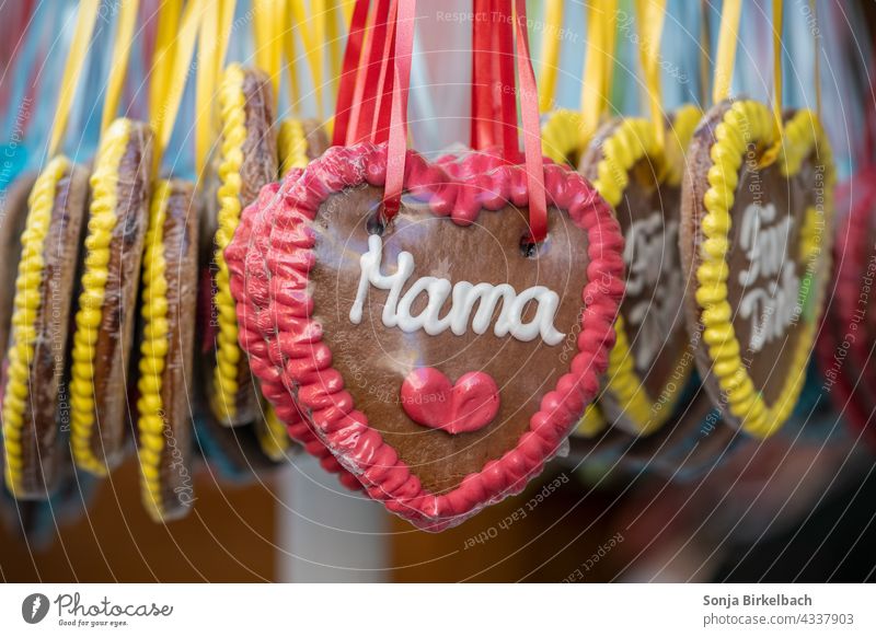 Gingerbread heart at a gingerbread stand at the carnival with the word mom mama Mom Mother hert Mother's Day funfair hustle and bustle Christmas Fair candy