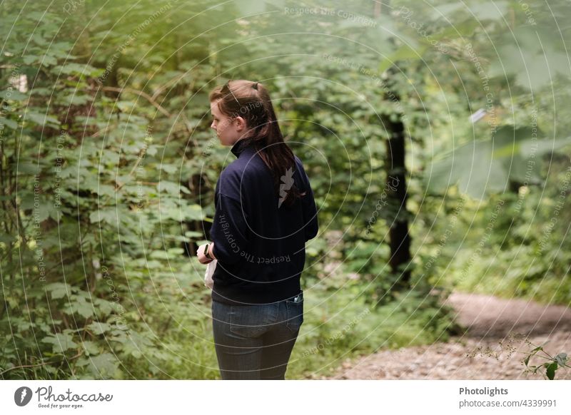 Young woman walks through the forest and observes something. Woman Nature Forest naturally Green Exterior shot Tree monitoring Hiking person Copy Space trees