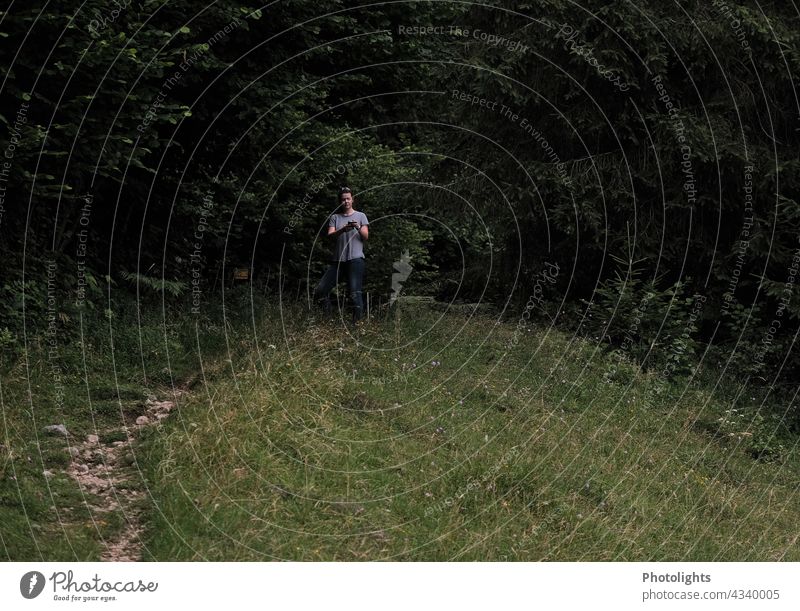 Young woman standing on a hill at the edge of the forest Wait waiting Emotions Lonely on one's own Landscape Observe Hiking Tree monitoring person Copy Space