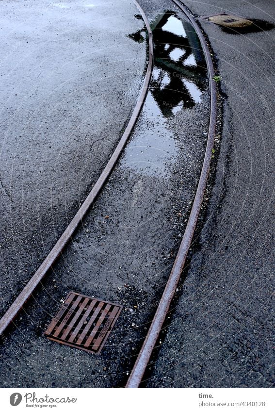 Track in asphalt with drain, puddle and reflection by rail Drainage Gully manhole cover Puddle Gray Wet Damp Water vibration curvature Parallel Asphalt track