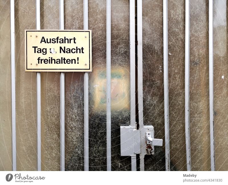 Yellow plastic sign on an old gate with rippled glass in front of a courtyard entrance in Offenbach am Main in Hesse plastic shield Yellowed interdiction Warn