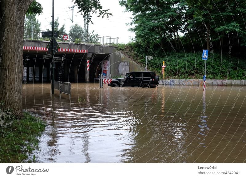 Extreme weather - an offroad vehicle tries to navigate on a flooded street in Düsseldorf, Germany climate climate change disaster dusseldorf düsseldorf