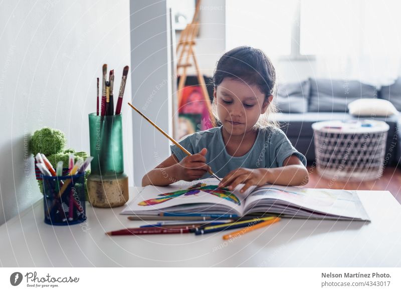 Little girl painting at home on the table happy playful female children young happiness person art paper inspiration little education kindergarten beautiful