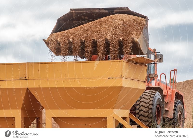 Bucket of an excavator pouring sand into silos. excavator shovel digger machine construction industry industrial architecture quarry old metal steel work iron