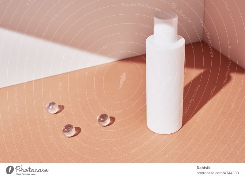 Natural cosmetic product. White bottle on pastel background cosmetics cream skin care mockup serum design minimal geometric shape shadow composition beige