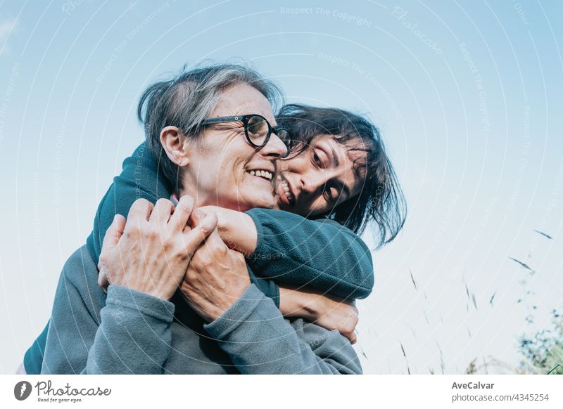 Senior woman and her daughter smiling and having fun on the nature during a sunny day. Happy mother's day joy laughing togetherness happiness people care face