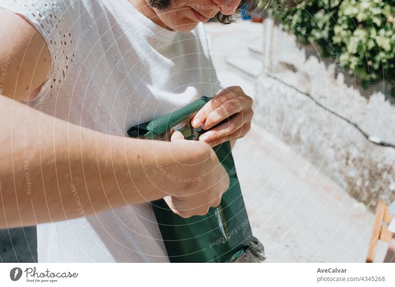 Woman close up opening a present during a sunny day indoor person woman grandmother lady receiving smiling care family gift affectionate aging anniversary