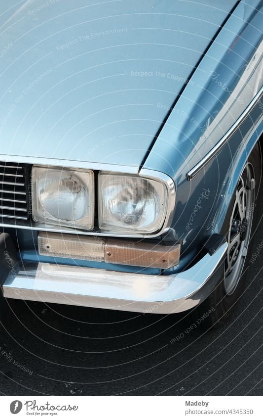 Angular double headlights of a blue french sedan of the seventies with shining chrome in the sunshine at the Golden Oldies in Wettenberg Krofdorf-Gleiberg near Giessen in Hesse