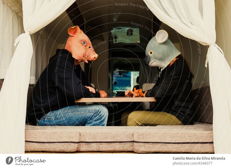 Couple with animals sitting at the table in a motorhome. Traveling couple. adventure animals mask auto home camper car driving freedom happy holiday house koala