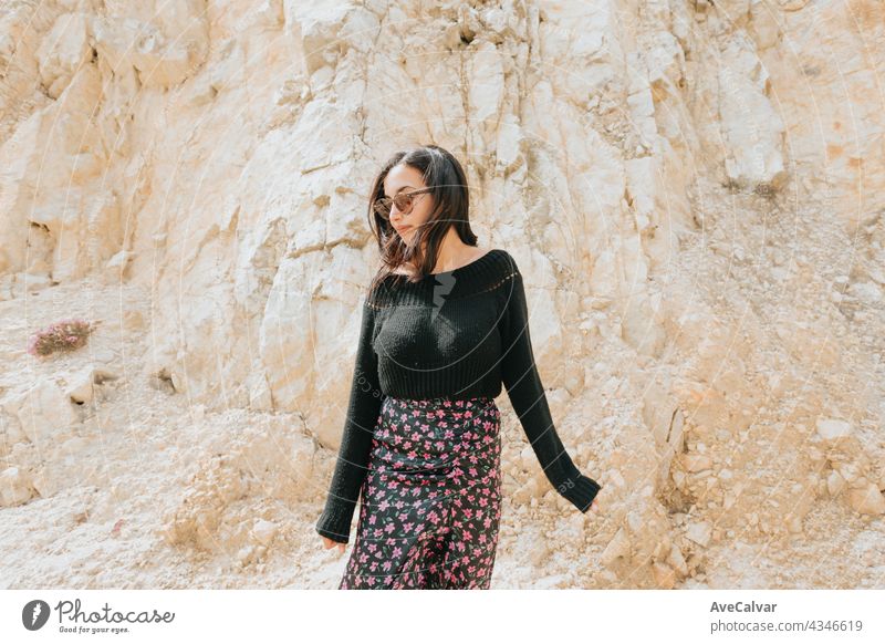 Portrait of a young woman with a pair of sunglasses in front of a marble giant rock, liberty and freedom concept lady smile person pretty enjoy model camera